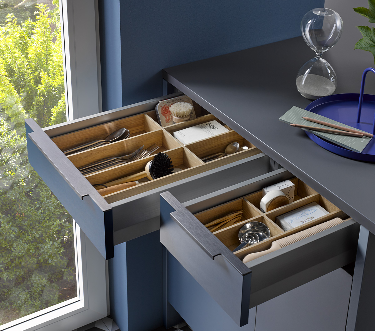 Un agencement intérieur astucieux des tiroirs et des coulissants dans une cuisine compacte Häcker