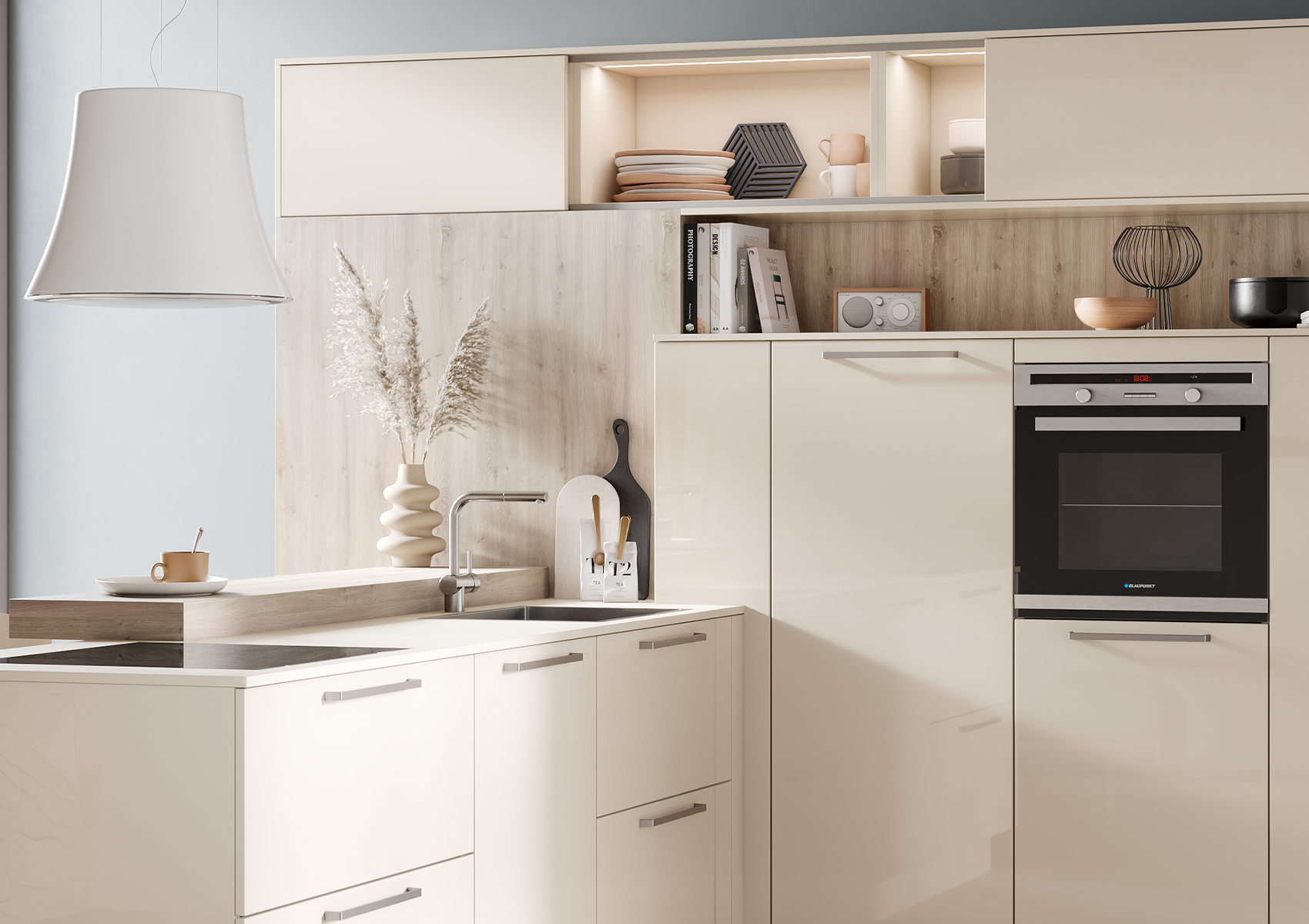Detailed picture of kitchen arrangement across the corner, on the left pull-outs in crema magnolia with bar handles, on the right wall unit with midi larder units and built-in cooker