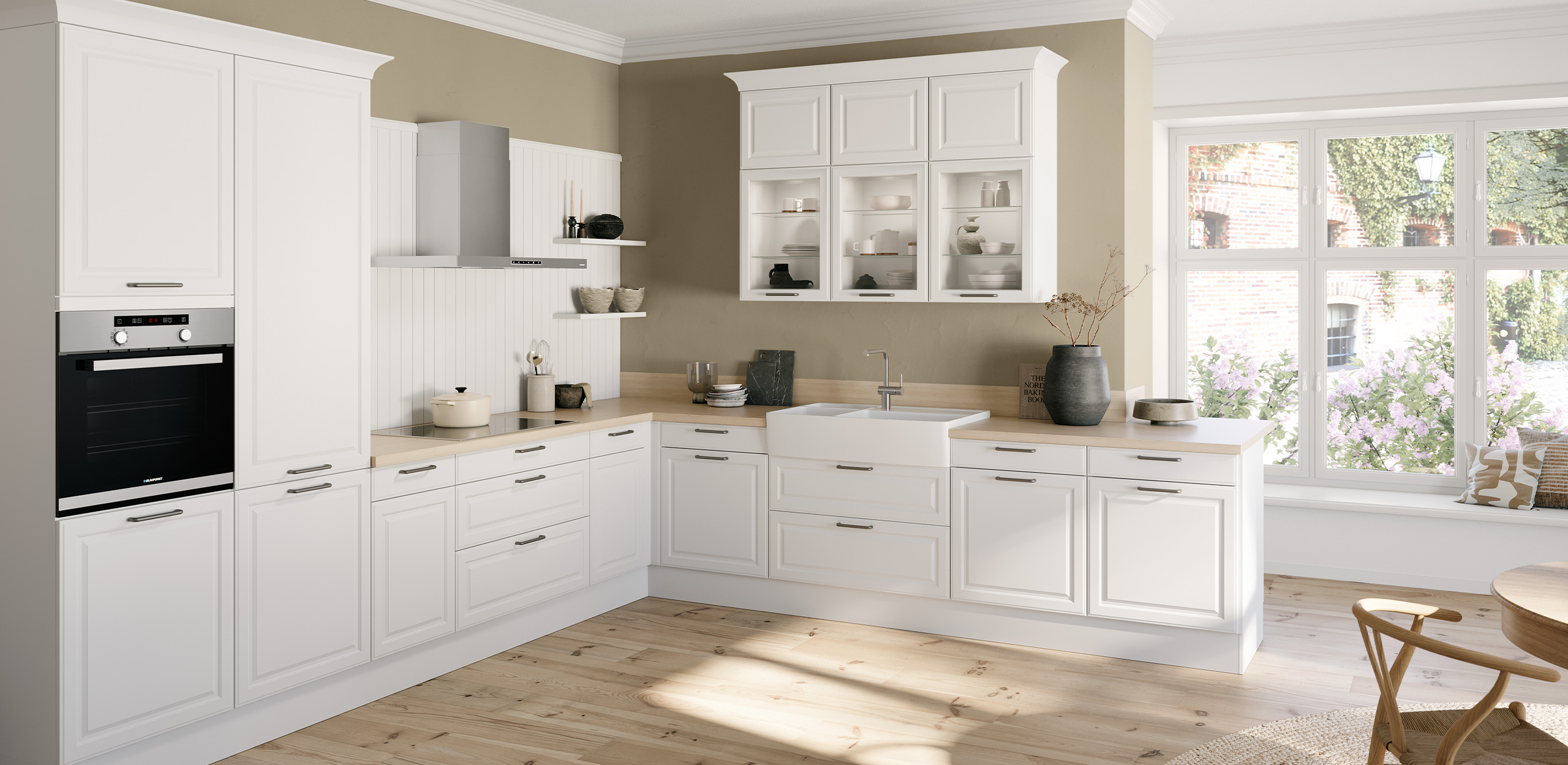 Imagen del conjunto de la cocina concept130 TOSKANA Crystal White con mueble de cocina en forma de L y zona de comedor truncada.