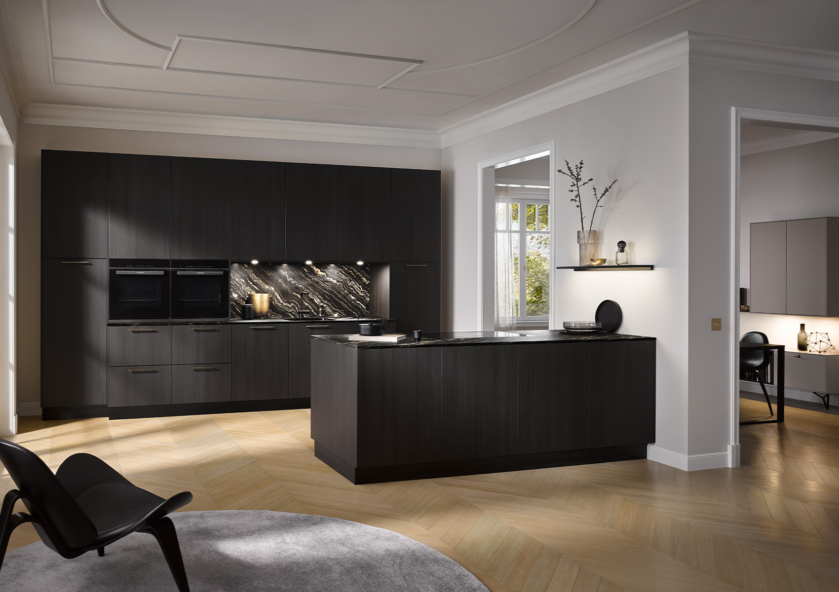 Image of a black kitchen AV 2040 Fine Black Oak with kitchen island, with dining area in the background